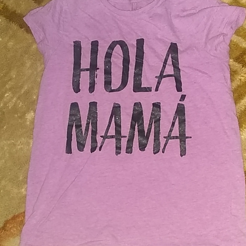 A purple shirt that say HOLA MAMA